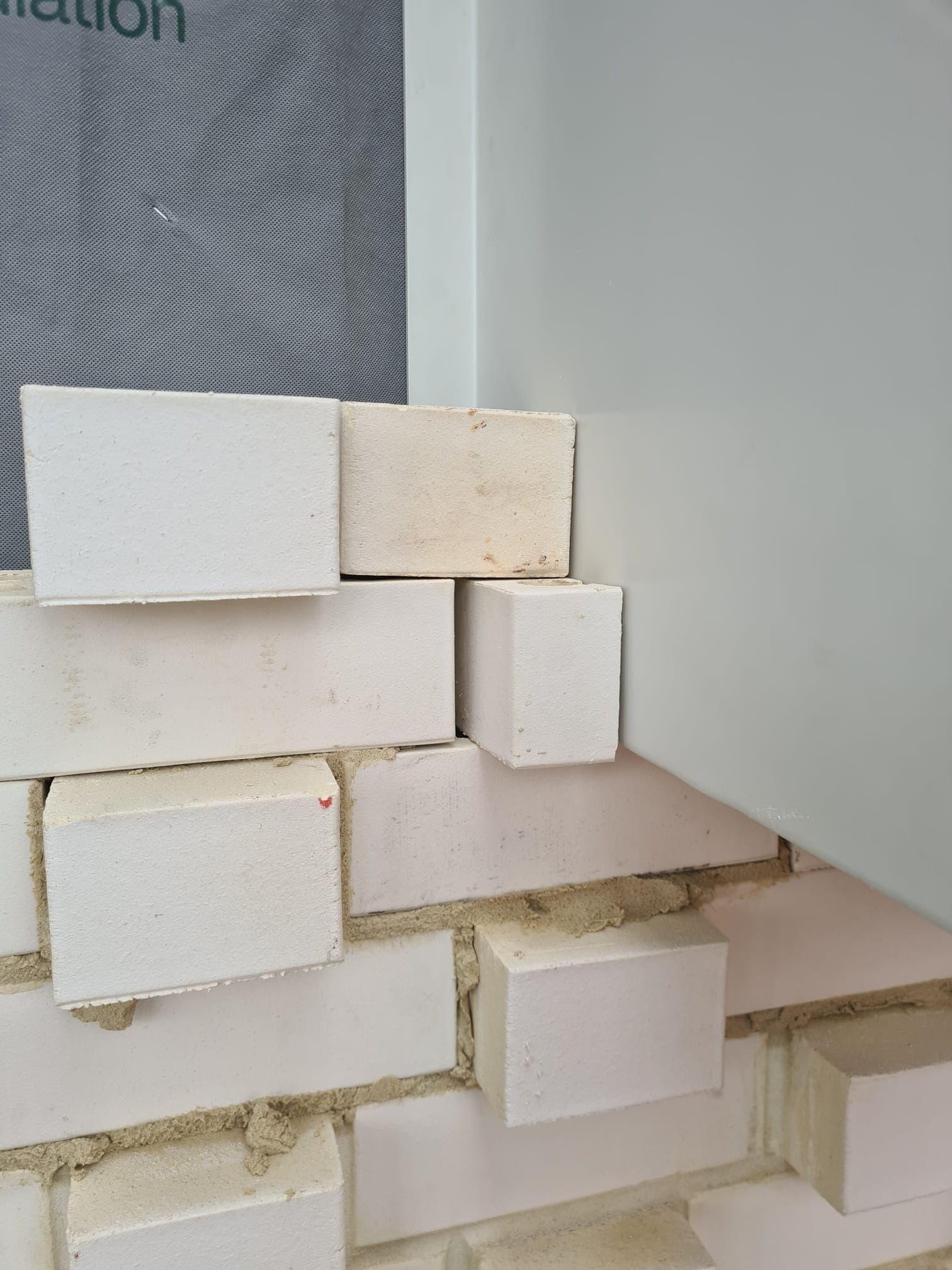 Close-up of dental-pattern brickwork detail on a textured facade by Goodwin Bricklaying