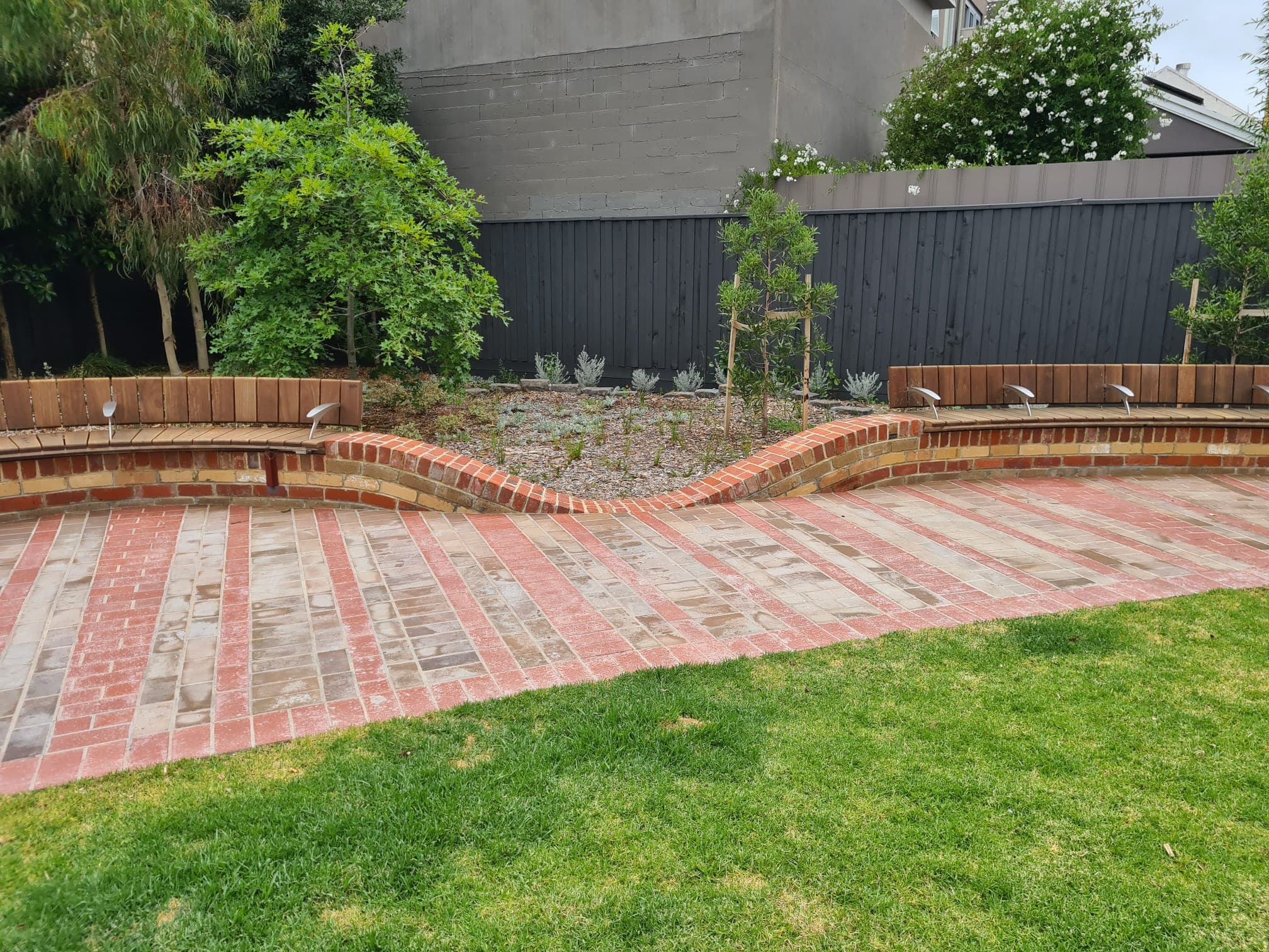 Curved architectural brick retaining wall built by Goodwin Bricklaying in a Prahran council park