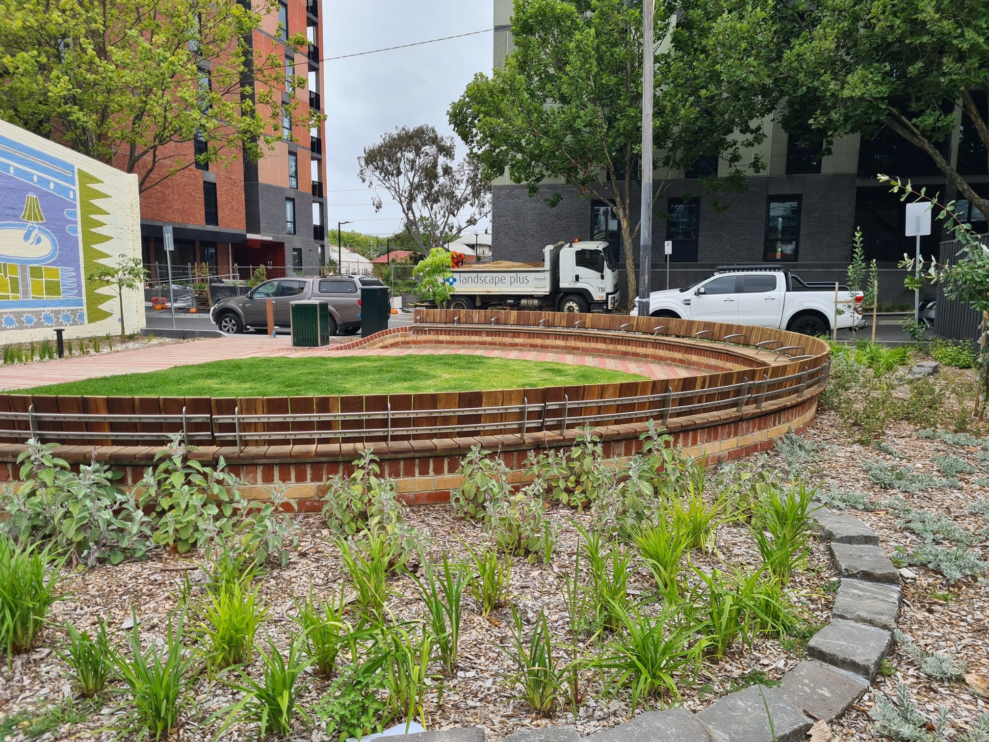 Curved architectural masonry wall with timber seating at a Prahran park