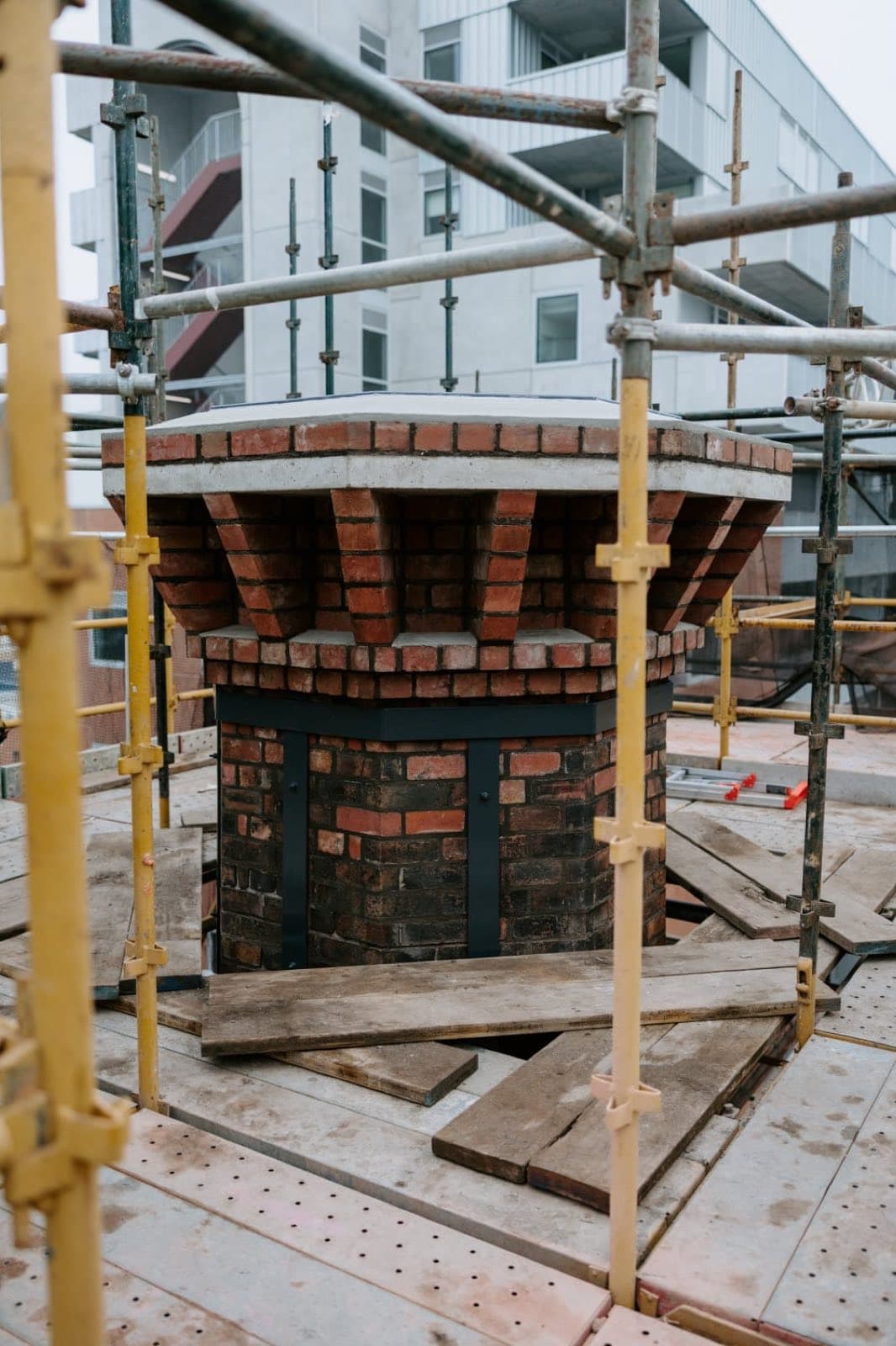 The rebuilt chimney crown of the Old Licorice Factory seen through the scaffolding, Brunswick