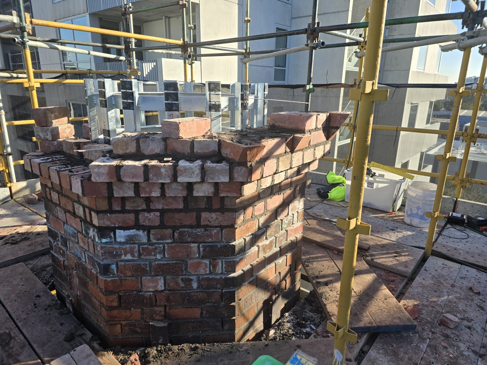 New corbelled brickwork on the Old Licorice Factory chimney restoration in Brunswick