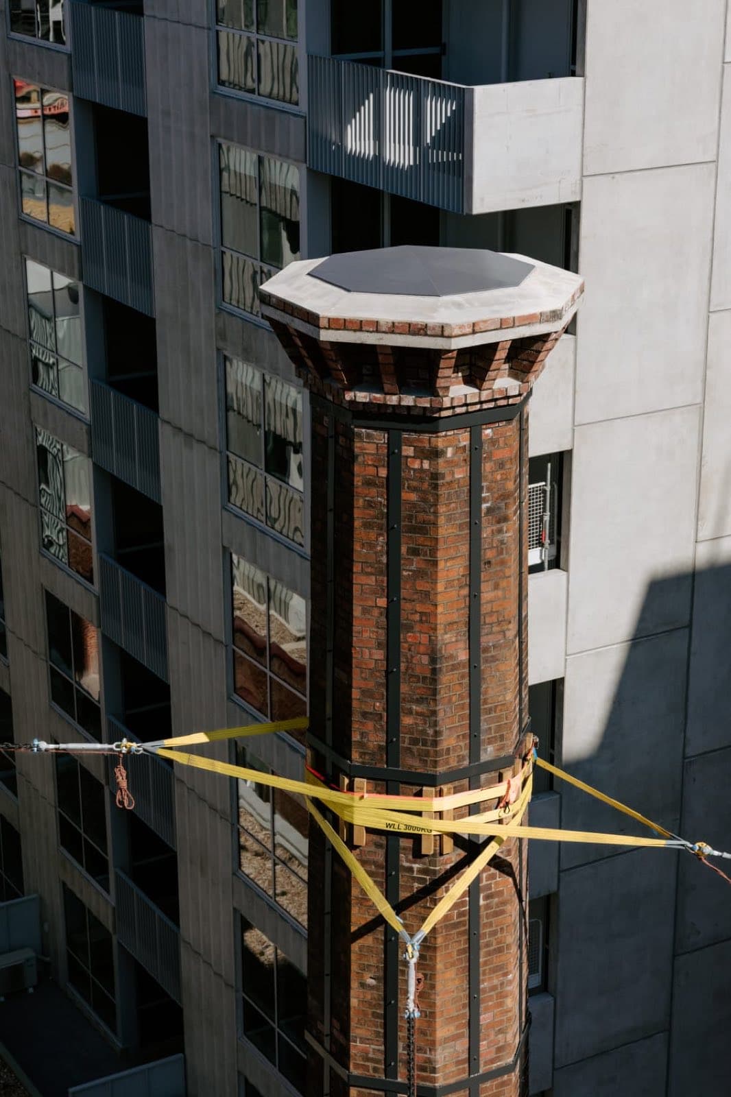 The rebuilt crown of the Old Licorice Factory chimney against the neighbouring apartment building, Brunswick