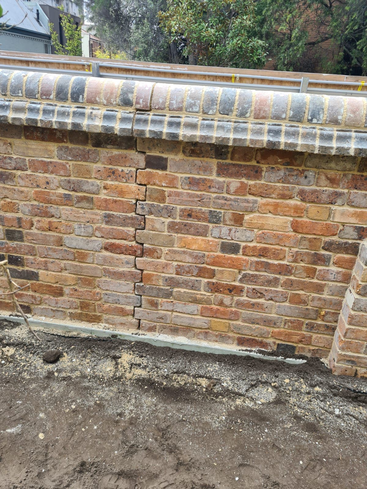A rebuilt section of the Cairo flats heritage wall on new footings, with its bullnose brick capping in place