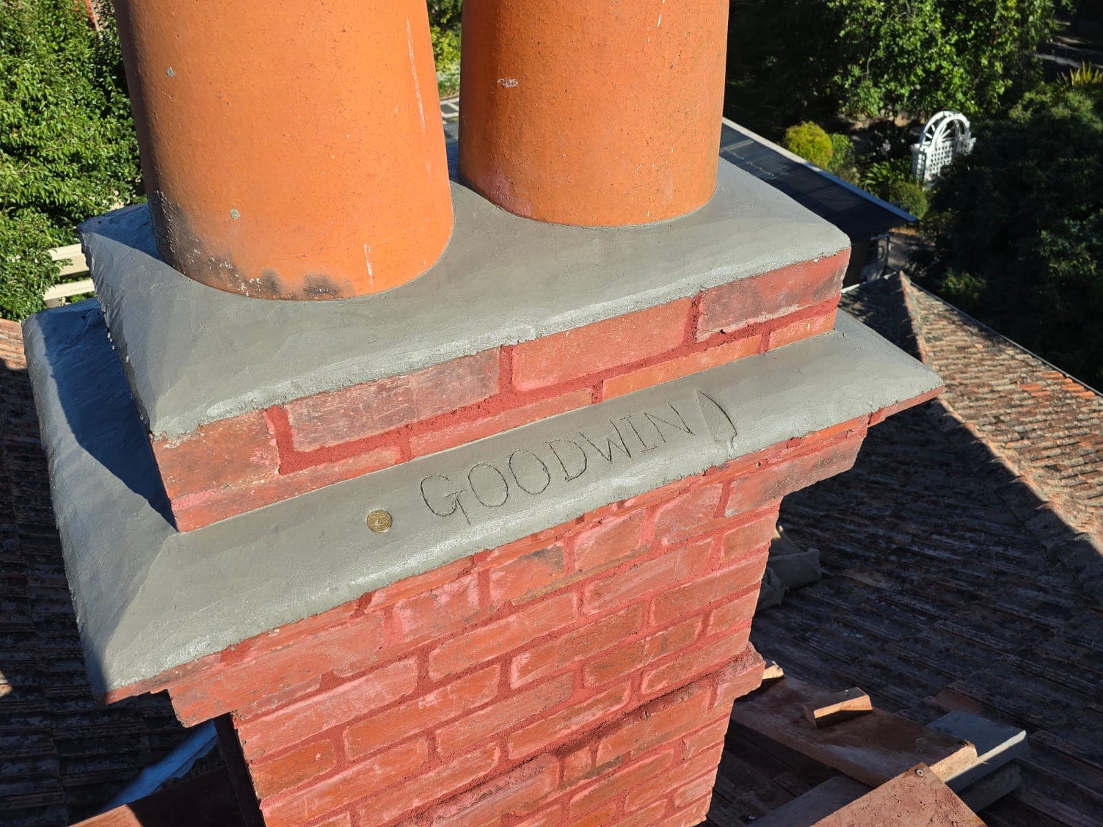 The Goodwin name carved into the new cement capping of a restored twin-pot heritage chimney