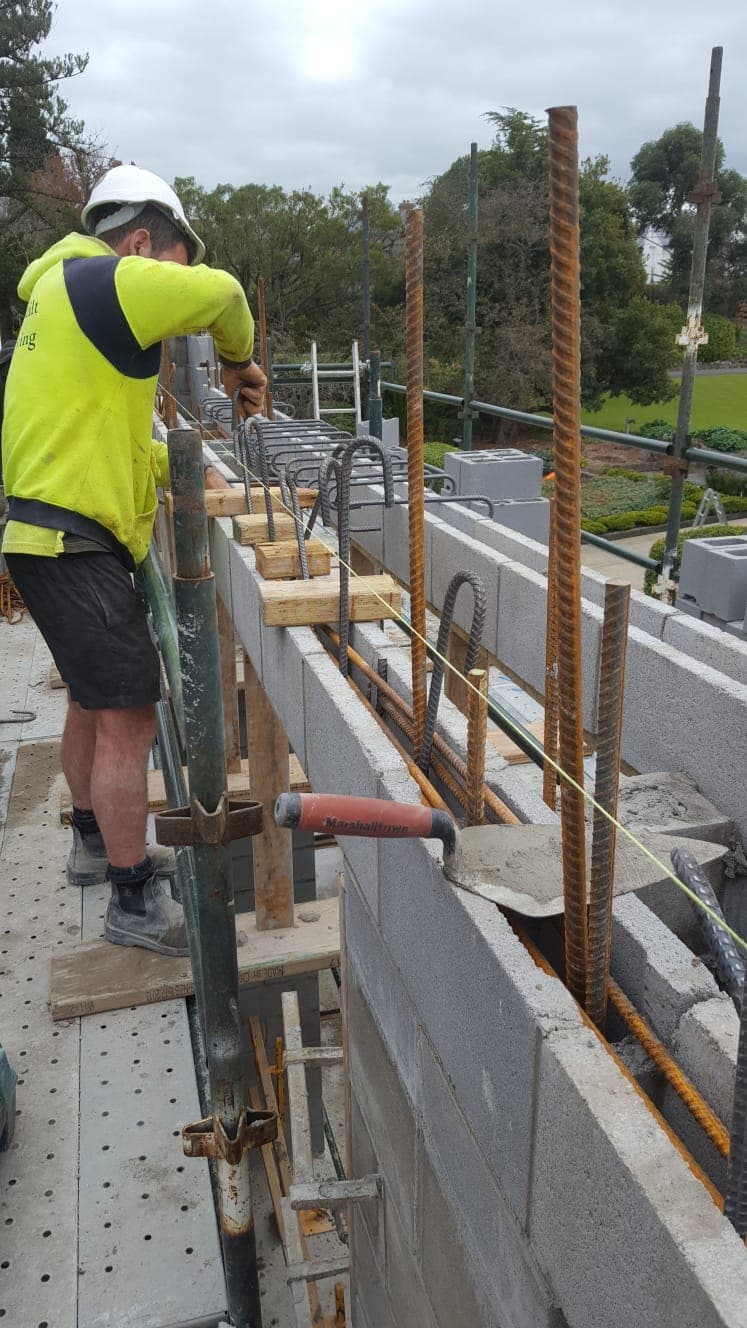 Precision-laid structural blockwork with steel reinforcement and scaffolding on a Melbourne build by Goodwin Bricklaying