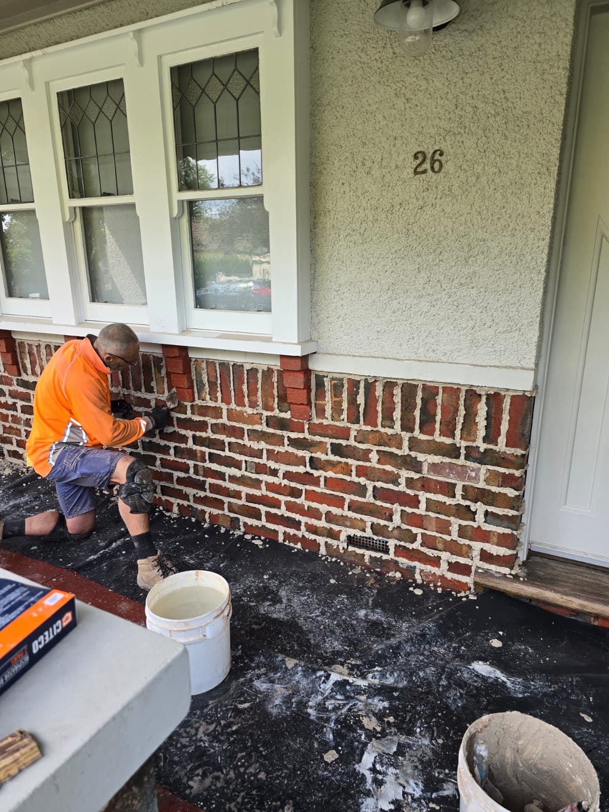 Tradesperson hand-finishing tuck pointing on weathered heritage brickwork, Goodwin Bricklaying Melbourne